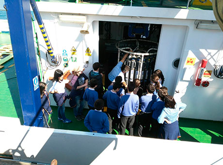 Un grupo de escolares en la cubierta del Alvariño recibe explicaciones sobre el funcionamiento de la roseta oceanográfica