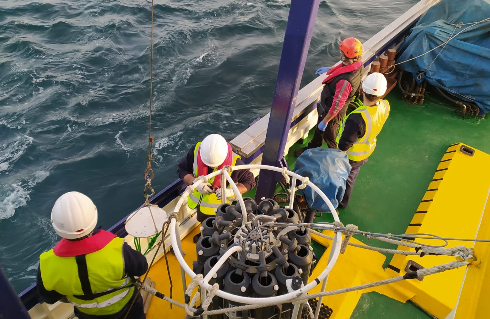 Científicos y tripulación colaboran en el muestreo del agua con la roseta oceanográfica.